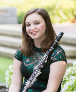 female holding a clarinet, out of doors